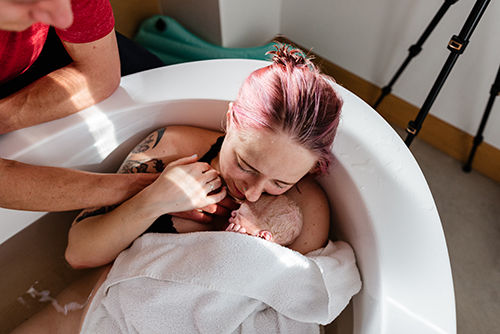 New mom and baby in birth tub